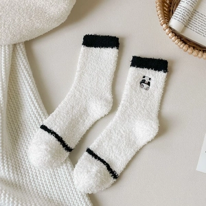 Close-up of soft coral fleece socks with cute panda embroidery and ribbed cuffs