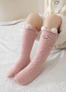 Gros plan sur les chaussettes en polaire corail rose avec oreilles 3D et broderie