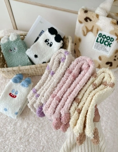 Close-up of thick coral fleece winter socks with cute cartoon animal embroidery details
