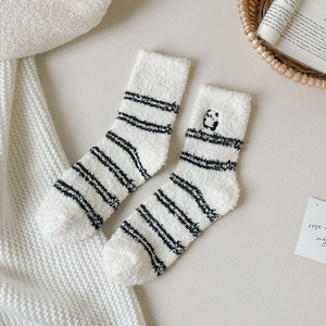 Close-up of soft coral fleece socks with cute panda embroidery and black stripes
