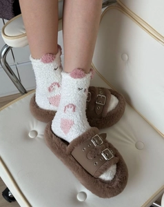 Gros plan de chaussettes en molleton corail doux avec broderie et pantoufles pelucheuses