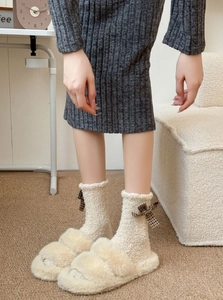 Close-up of cozy coral fleece socks with plaid bows and matching fuzzy slippers