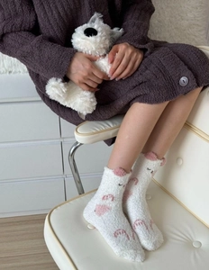 Détail des chaussettes en molleton corail avec oreilles 3D roses et broderie de pattes