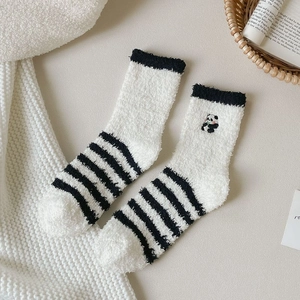 Detailed close-up of striped coral fleece socks featuring cute panda embroidery