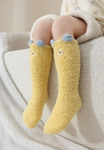 Détail de chaussettes en polaire corail jaune avec oreilles 3D bleues pour enfants