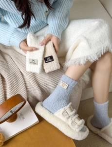 Detailed texture of thick coral fleece mid-calf socks with cute bear brand patches