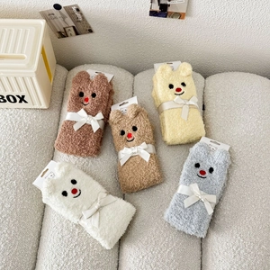 Fünf Paar dicke Korallenvlies-Tiersocken mit Bärenstickerei auf einem weißen Sofa