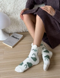 Gros plan de chaussettes d'hiver en polaire corail avec oreilles d'ours et fleurs