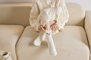 Detail von weißen Korallenvlies-Wintersocken mit süßem Tiermotiv und weicher, dicker Textur