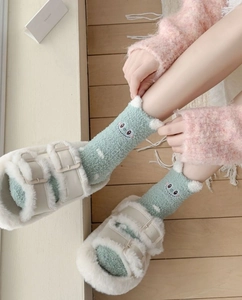 Detail of green coral fleece warm socks with cartoon monster embroidery and 3D plush ears
