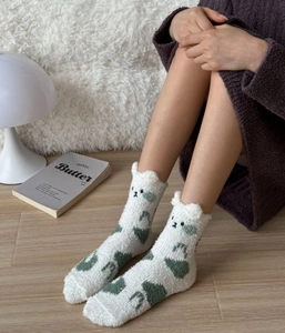Détail de chaussettes en polaire corail blanche avec broderie ours vert et oreilles 3D
