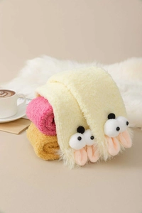 Close-up of thick coral fleece socks with cute cartoon long ears in three warm colors