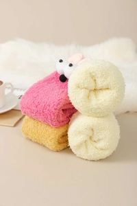 Close-up of thick coral fleece winter socks in pink, yellow, and beige for home comfort