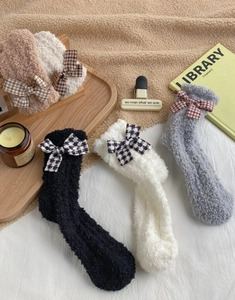 Detailed view of warm coral fleece socks with elegant checkered bows in various colors