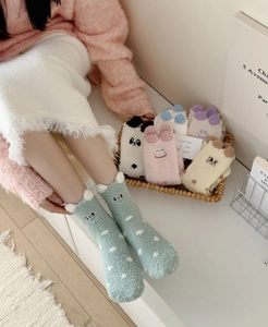 Close-up of warm coral fleece mid-calf socks with cute cartoon animal embroidery