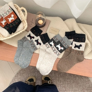 Détail de chaussettes en tricot chaud avec motifs caniche aux couleurs d'automne rétro