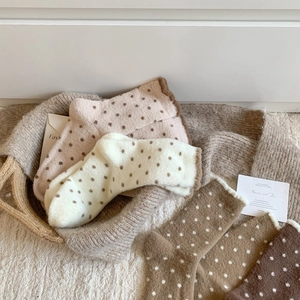 Vue détaillée des chaussettes chaudes à pois aux tons terre avec bords ondulés décoratifs