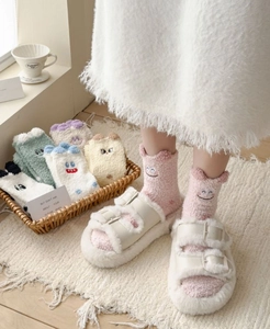 Close-up of coral fleece socks with cute cartoon animal embroidery and 3D ears detail