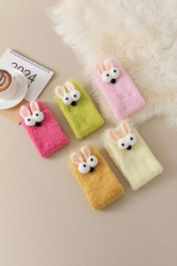 Detail of colorful coral fleece thermal socks with cute 3D bunny ears for winter