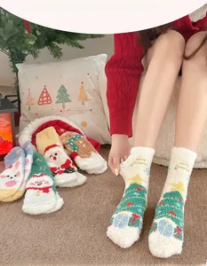 Détail des chaussettes de Noël en polaire corail avec motifs festifs du Père Noël et de cerf