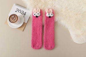 Detailed view of pink coral fleece socks with 3D cartoon bunny ears and soft plush texture