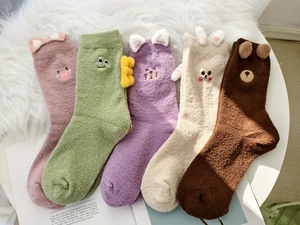 Flat lay of five cartoon animal coral fleece socks in soft pastel colors and cute 3D ears