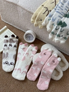 Gros plan de chaussettes d'hiver en polaire corail avec broderies d'animaux mignons