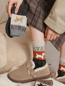 Détail de chaussettes en tricot avec jacquard de chien mignon et motif cœur rouge