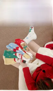 Détail de chaussettes de Noël en molleton corail doux avec motifs festifs d'animaux et sapins