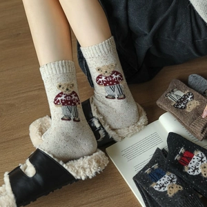 Close-up of cute cartoon bear jacquard on cozy knitted crew socks with ribbed cuffs