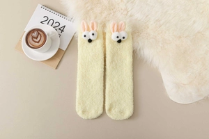 Close-up of yellow coral fleece socks with cute 3D bunny ears for home warmth
