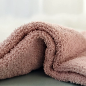 Macro shot of thick pink coral fleece fabric with soft plush texture for winter socks