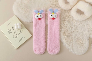 Detail of pink coral fleece thermal socks featuring cute cartoon 3D eyes and blue ears