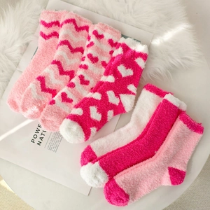 Detailed set of five pink and white coral fleece socks featuring heart and stripe patterns