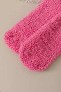 Close-up of soft pink coral fleece socks showing thick warm plush fabric texture