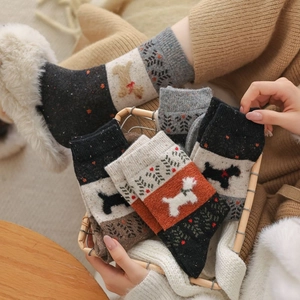 Gros plan de chaussettes d'hiver épaisses avec motifs de chiens et textures nordiques