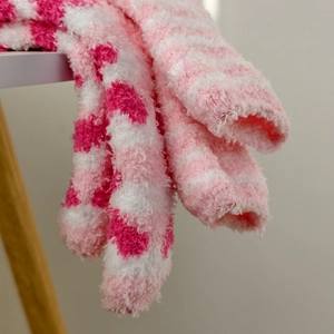 Close-up of pink coral fleece socks showing soft plush texture and striped pattern