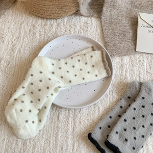 Gros plan de chaussettes pelucheuses à pois crème et marron pour chaleur hivernale
