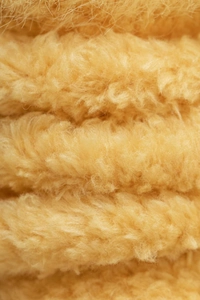 Close-up of thick yellow coral fleece fabric showing soft and warm fluffy texture