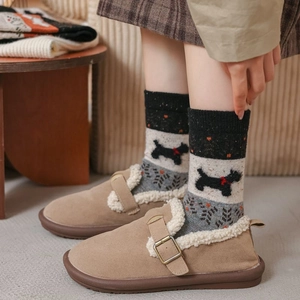 Détail de chaussettes d'hiver chaudes à motif de chien et mules fourrées douces