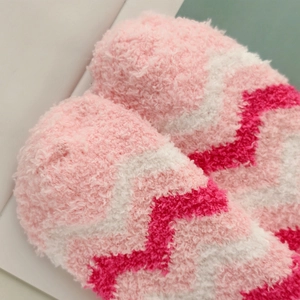 Macro detail of plush pink and magenta wave pattern coral fleece socks for winter warmth