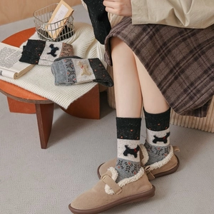 Détail de chaussettes en tricot épais avec motif chien Terrier et jacquard d'arbres de forêt