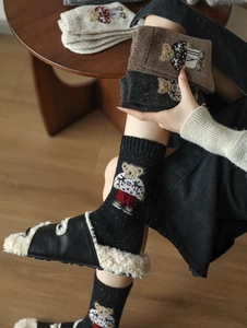 Close-up of knitted crew socks with cute bear jacquard pattern and wide ribbed cuffs