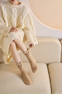 Nahaufnahme der flauschigen Korallenvlies-Socken mit braunem Rentier-Stick und 3D-Ohren