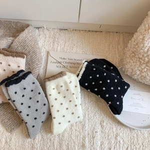 Gros plan de chaussettes thermiques à pois épais en couleurs assorties avec peluche