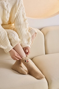 Detailansicht der flauschigen Korallenvlies-Socken mit Rentier-Stickerei und 3D-Ohren