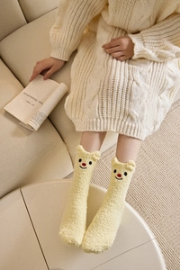 Detail von gelben Korallenfleece-Thermosocken mit 3D-Tierohren und Bärenstickerei