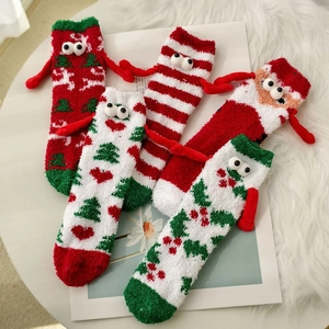 Flat lay of five fluffy Christmas socks with 3D eyes and hands on a plush background