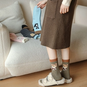Close-up of thick winter wool socks with cute cartoon bear embroidery and ribbed cuffs