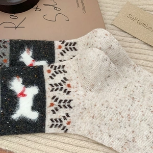 Détail de chaussettes d'hiver avec motif chien et texture tricotée nordique